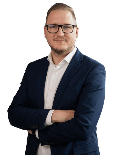 Thomas Hübner im blauen Blazer vor neutralem Hintergrund